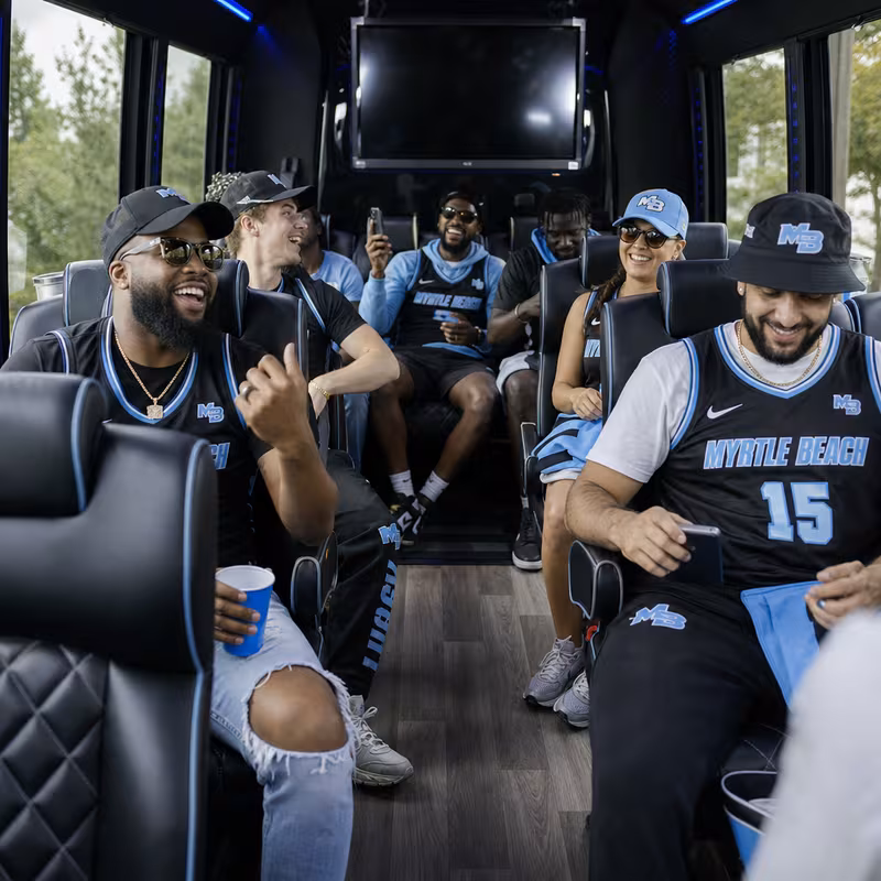 Group boarding a white charter bus for Sporting Event Transportation transportation in Myrtle Beach